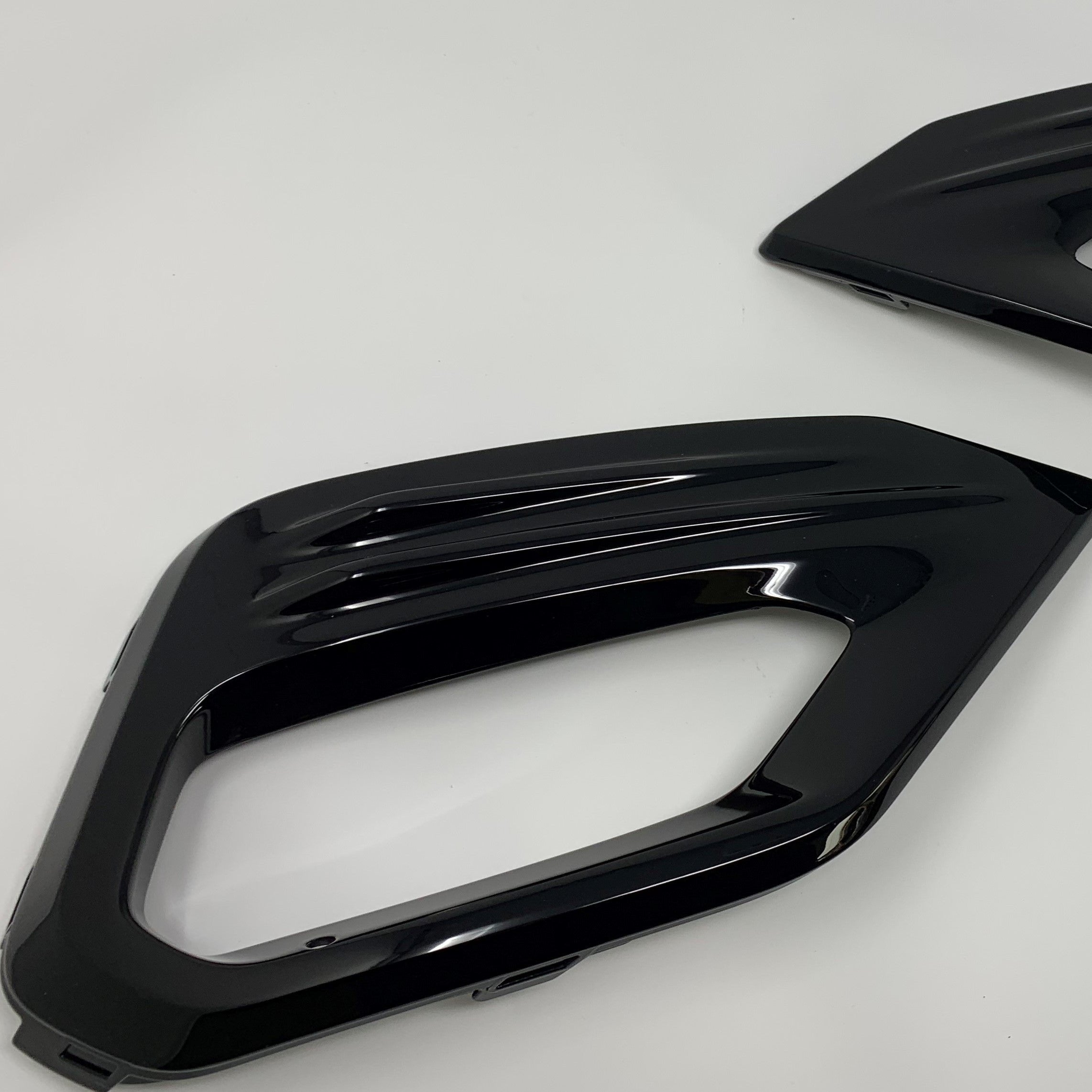 A pair of gloss black painted fog light surrounds for a Ford Fiesta Mk8 ST/ST Line.